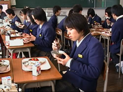 教室で給食を食べている学生の写真